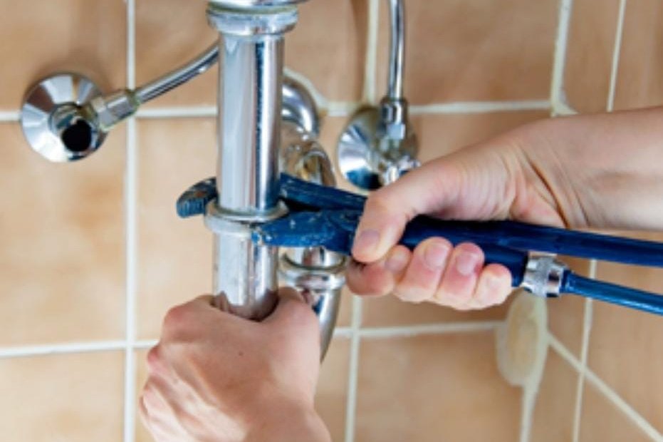 Siphon unter dem Waschbecken wird mit der Wasserpumpenzange angezogen
